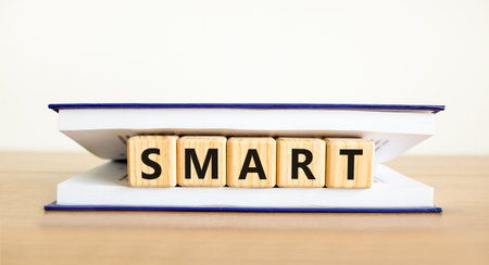 Smart symbol. Concept word Smart on beautiful wooden blocks in book. Beautiful wooden table white background. Business lifestyle smart concept. Copy space.の写真素材