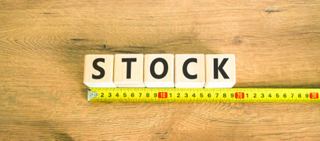 Stock symbol. Concept word Stock on beautiful wooden blocks. Beautiful wooden table wooden background. Beautiful yellow ruler. Business lifestyle stock concept. Copy space.の写真素材