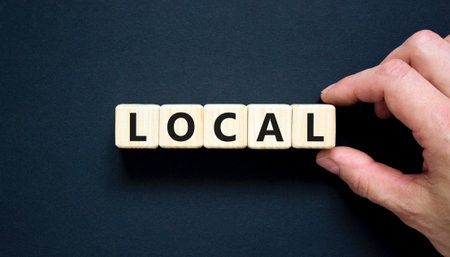 Local symbol. Concept word Local on beautiful wooden blocks. Beautiful black table black background. Businessman hand. Business lifestyle local concept. Copy space.の写真素材