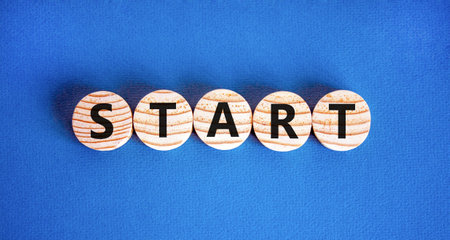 Start symbol. Concept word Start on beautiful wooden circles. Beautiful blue table blue background. Business lifestyle start concept. Copy space.の写真素材
