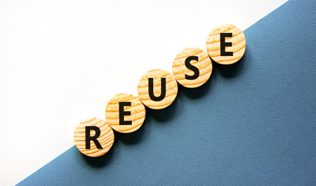 Reuse symbol. Concept word Reuse on beautiful wooden circles. Beautiful white and blue background. Business lifestyle ecological reuse concept. Copy space.の写真素材