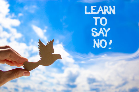 Learn to say no symbol. Concept words phrase Learn to say no on beautiful blue sky. Businessman's hand. Beautiful blue sky clouds background. Business psychological Learn to say no concept. Copy spaceの写真素材