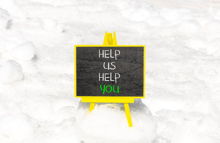 Help you symbol. Concept words phrase Help us help you on beautiful black blackboard. Beautiful white snow background. Business Help you concept. Copy space.の写真素材