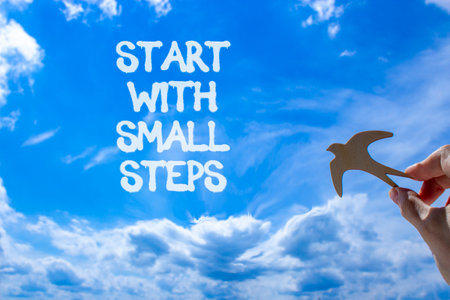 Start with small steps symbol. Concept words phrase Start with small steps on beautiful blue sky....