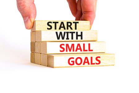 Start with small goals symbol. Concept words phrase Start with small goals on beautiful wooden blocks. Beautiful white background. Businessman hand Business Start with small goals concept. Copy space.の写真素材
