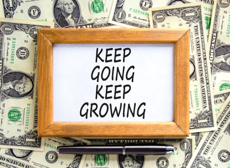Keep going and growing symbol. Concept words phrase Keep going keep growing on beautiful picture frame. Dollar bills. Beautiful dollar bills background. Business Keep going growing concept. Copy spaceの写真素材