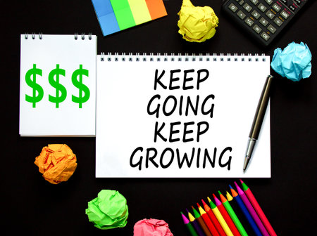 Keep going and growing symbol. Concept words phrase Keep going keep growing on beautiful white note. Colored paper. Beautiful black background. Business Keep going and growing concept. Copy space.の写真素材