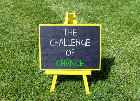 The challenge of chance symbol. Concept words phrase The challenge of chance on beautiful black blackboard. Beautiful green grass lawn background. Business The challenge of chance concept. Copy space.の写真素材