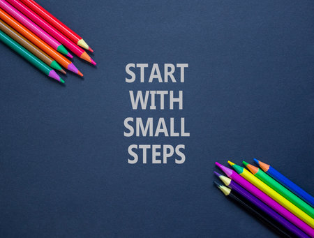 Start with small steps symbol. Concept words phrase Start with small steps on beautiful paper. Colored pencils. Beautiful black paper background. Business Start with small steps concept. Copy space.の写真素材