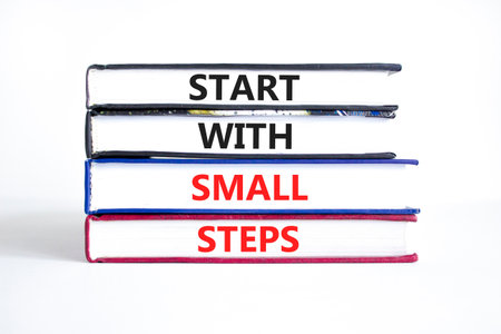 Start with small steps symbol. Concept words phrase Start with small steps on beautiful books. Beautiful white paper background. Business Start with small steps concept. Copy space.の写真素材