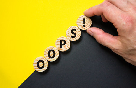 Oops symbol. Concept word Oops on beautiful wooden circles. Beautiful yellow and black background....