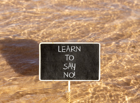Learn to say no symbol. Concept words phrase Learn to say no on beautiful black blackboard. Beautiful Red sea water background. Business psychological Learn to say no concept. Copy space.の写真素材
