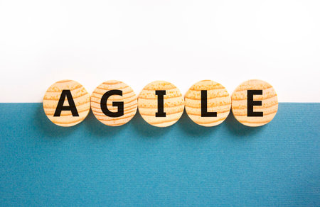 Agile symbol. Concept word Agile on beautiful wooden circles. Beautiful white and blue background. Business flexible and agile concept. Copy space.の写真素材