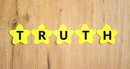 Truth symbol. Concept word Truth on beautiful yellow paper stars. Beautiful wooden table wooden background. Business lifestyle truth concept. Copy space.の写真素材