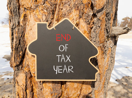End of tax year symbol. Concept words phrase End of tax year on beautiful black blackboard. Beautiful old pine tree background. Business End of tax year concept. Copy space.の写真素材