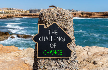 The challenge of chance symbol. Concept words phrase The challenge of chance on beautiful black blackboard. Beautiful stone blue sea background. Business The challenge of chance concept. Copy space.の写真素材