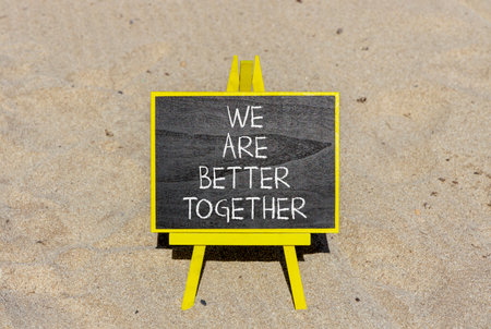 We are better together symbol. Concept words phrase We are better together on beautiful black blackboard. Beautiful sand beach background. Business We are better together concept. Copy space.の写真素材