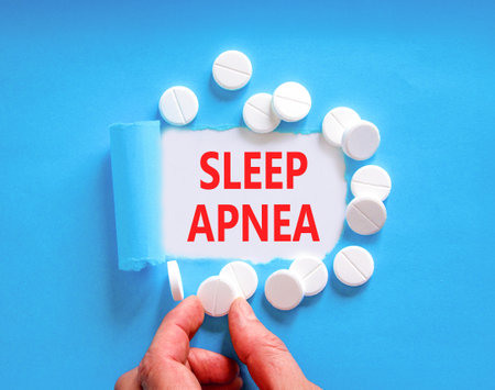 Sleep apnea symbol. Concept words Sleep apnea on beautiful white paper. White pills tablets. Doctor's hand. Beautiful blue background. Medical healthy lifestyle sleep apnea concept.の写真素材