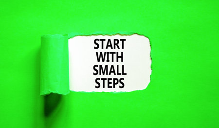 Start with small steps symbol. Concept words phrase Start with small steps on beautiful white paper. Beautiful green paper background. Business Start with small steps concept. Copy space.の写真素材