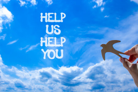 Help you symbol. Concept words phrase Help us help you on beautiful blue sky. Businessman's hand. Beautiful blue sky clouds background. Business Help you concept. Copy space.の写真素材