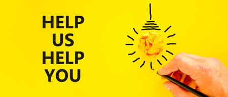 Help you symbol. Concept words phrase Help us help you on beautiful yellow paper. Businessman's hand. Light bulb icon. Beautiful yellow paper background. Business Help you concept. Copy space.の写真素材