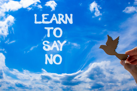 Learn to say no symbol. Concept words phrase Learn to say no on beautiful blue sky. Businessman's hand. Beautiful blue sky clouds background. Business psychological Learn to say no concept. Copy spaceの写真素材