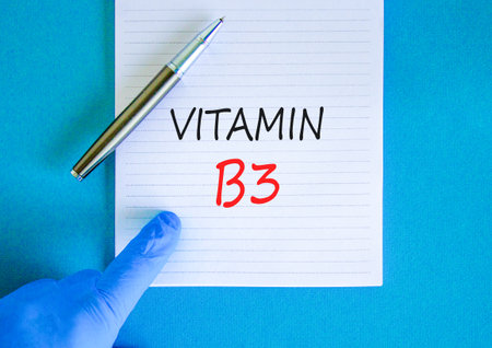 Vitamin B3 niacin symbol. Concept words Vitamin B3 on beautiful white note. Doctor's hand in blue medical glove. Beautiful blue background. Medical healthy lifestyle Vitamin B3 niacin concept.の写真素材