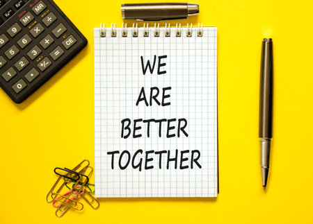 We are better together symbol. Concept words phrase We are better together on beautiful note. Black pen. Calculator. Beautiful yellow background. Business We are better together concept. Copy spaceの写真素材