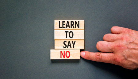 Learn to say no symbol. Concept words phrase Learn to say no on beautiful wooden blocks. Beautiful gray paper background. Businessman's hand. Business psychological Learn to say no concept. Copy spaceの写真素材