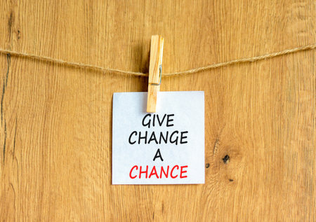Give change a chance symbol. Concept words phrase Give change a chance on beautiful white paper on wooden clothespin. Beautiful wooden background. Business Give change a chance concept. Copy space.の写真素材