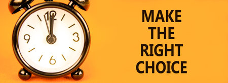 Make the right choice symbol. Concept words phrase Make the right choice on beautiful orange paper. Black alarm clock. Beautiful orange background. Business Make the right choice concept. Copy space.の写真素材