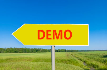 Demo symbol. Concept word Demo on beautiful yellow road sign. Beautiful blue sky green grass and forest peaceful nature background. Business and demo concept. Copy space.の写真素材