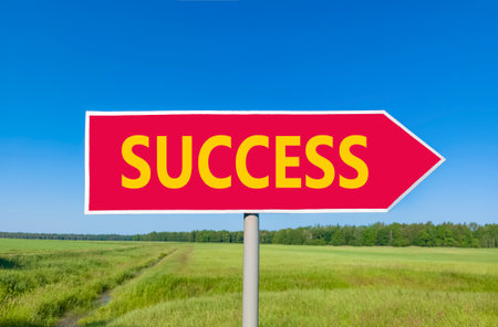 Success symbol. Concept word Success on beautiful red road sign. Beautiful blue sky green grass and forest peaceful nature background. Business success concept. Copy space.の写真素材