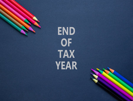 End of tax year symbol. Concept words phrase End of tax year on beautiful black paper. Colored pencils. Beautiful black paper background. Business End of tax year concept. Copy space.の写真素材