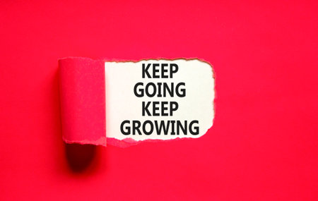 Keep going and growing symbol. Concept words phrase Keep going keep growing on beautiful white paper. Beautiful red paper background. Business Keep going and growing concept. Copy space.の写真素材