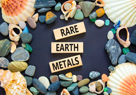 Rare earth metals symbol. Concept words Rare earth metals on beautiful wooden block. Sea stones and...