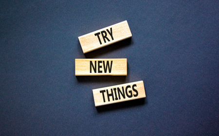 Try new things symbol. Concept words Try new things on beautiful wooden block. Beautiful black table black background. Business motivational lifestyle try new things concept. Copy space.の写真素材