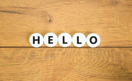 Hello symbol. Concept word Hello on beautiful white pills circles. Beautiful wooden table wooden background. Business lifestyle hello concept. Copy space.の写真素材