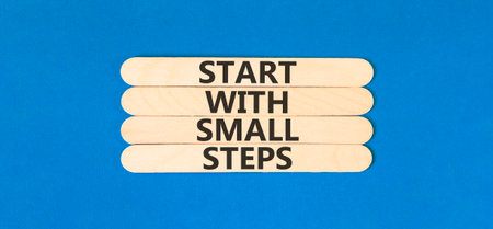 Start with small steps symbol. Concept words phrase Start with small steps on beautiful wooden stick. Beautiful blue paper background. Business Start with small steps concept. Copy space.の写真素材