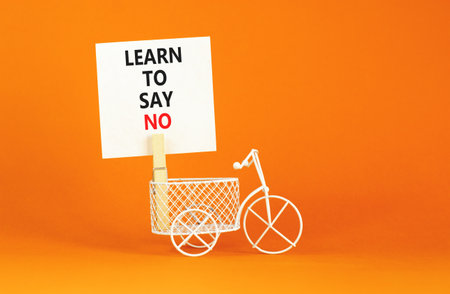 Learn to say no symbol. Concept words phrase Learn to say no on beautiful white paper on wooden clothespin. Beautiful orange paper background. Business psychological Learn to say no concept Copy spaceの写真素材