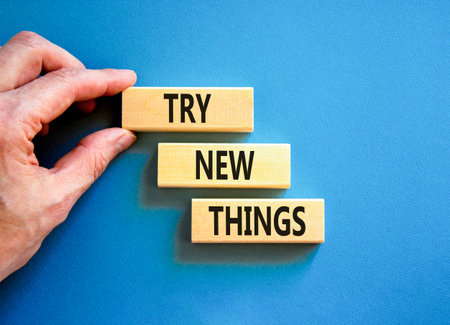 Try new things symbol. Concept words Try new things on beautiful wooden block. Businessman's hand. Beautiful blue background. Business motivational lifestyle try new things concept. Copy space.の写真素材