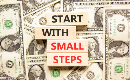 Start with small steps symbol. Concept words phrase Start with small steps on beautiful blocks. Dollar bills. Beautiful dollar bills background. Business Start with small steps concept. Copy spaceの写真素材
