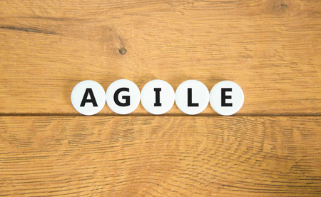 Agile symbol. Concept word Agile on beautiful white pills circles. Beautiful wooden table wooden background. Business flexible and agile concept. Copy space.の写真素材