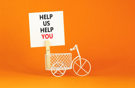 Help you symbol. Concept words phrase Help us help you on beautiful white paper on wooden clothespin. Miniature bicycle. Beautiful orange paper background. Business Help you concept. Copy space.の写真素材