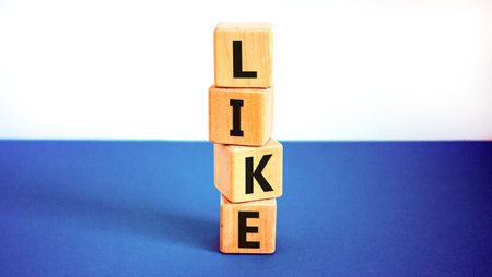 Like symbol. Concept word Like on beautiful wooden blocks. Beautiful white and blue background. Business, lifestyle, support and like concept. Copy space.の写真素材