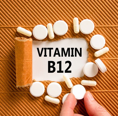 Vitamin B12 symbol. Concept words Vitamin B12 on beautiful white paper. White pills tablets. Doctor's hand. Beautiful brown background. Medical healthy lifestyle Vitamin B12 concept.の写真素材