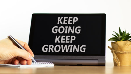 Keep going and growing symbol. Concept words phrase Keep going keep growing on beautiful tablet. Businessman's hand. Beautiful white background. Business Keep going and growing concept. Copy space.の写真素材