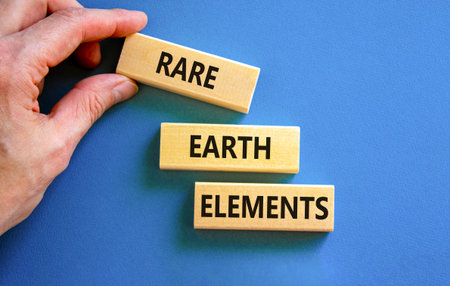 Rare earth elements symbol. Concept words Rare earth elements on beautiful wooden block. Businessman's hand. Beautiful blue background. Business and rare earth elements concept. Copy space.の写真素材