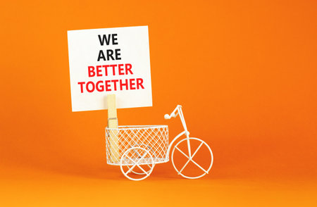 We are better together symbol. Concept words phrase We are better together on beautiful white paper on clothespin. Beautiful orange background. Business We are better together concept. Copy space.の写真素材
