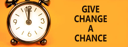Give change a chance symbol. Concept words phrase Give change a chance on beautiful orange paper. Black alarm clock. Beautiful orange paper background. Business Give change a chance concept Copy spaceの写真素材